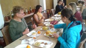 Eine Gruppe von Menschen, die an einem Tisch sitzen und Essen essen. in der Unterkunft Italiano Safari House in Udawalawe