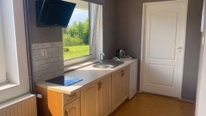 a kitchen with a sink and a window at Na Poczatku - Apartamenty in Darłowo +30 photos