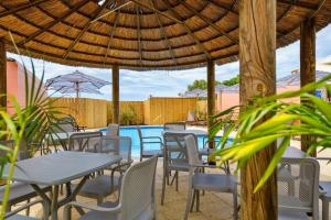 un groupe de tables et de chaises sous un parapluie en bois dans l'établissement Osprey Holiday Village Unit 222 1 Bedroom, à Exmouth 5 autres photos