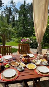 Neli & Zaal Guest House في تيلافي: طاولة خشبية عليها صحون طعام