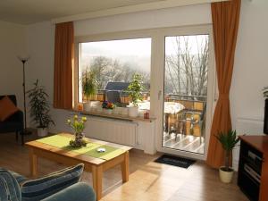 ein Wohnzimmer mit einem Tisch und einem großen Fenster in der Unterkunft Mountainview villa in Wiemeringhausen