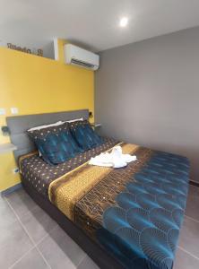Schlafzimmer mit einem Bett mit blauer Bettwäsche und blauen Kissen in der Unterkunft Grey Diamond Studio in Le Diamant
