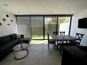 uma sala de estar com um sofá e uma mesa em Modern Beautiful Condo em Mezcales