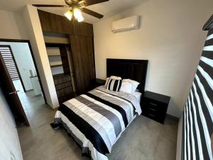 um quarto com uma cama e uma ventoinha de tecto em Modern Beautiful Condo em Mezcales
