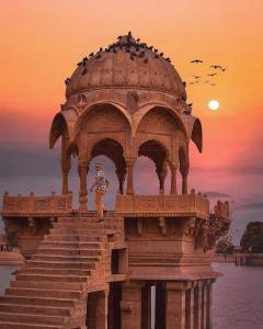 una estatua sentada en la parte superior de un edificio con escaleras en Hotel Golden Night Jaisalmer en Jaisalmer