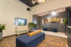 a living room with a blue couch and a mirror at Tasme Hotel in Da Lat