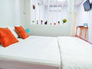 a white bed with orange pillows in a room at whole house for 5 guests 3 beds in Hat Yai