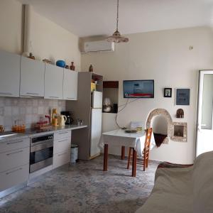 uma cozinha com armários brancos e uma mesa em Erato Elafonisi em Agios Padeleimon