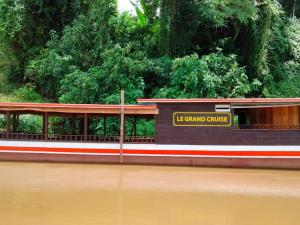 Un tren que viaja por un río junto a un cuerpo de agua en Le Grand Cruise Package en Muang Pakbèng