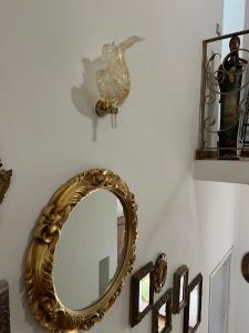 a gold mirror on a wall with a bird on it at Da Tea in San Teodoro