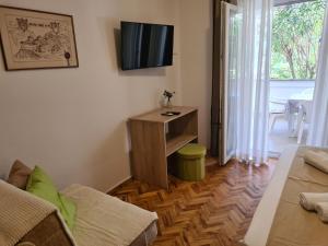 a living room with a tv on the wall at Apartments Ivo in Pag