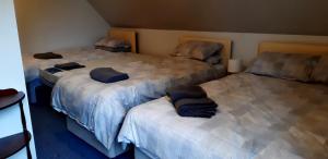 a room with three beds with blue pillows on them at Spacious one bedroom apartment in North Kessock in Inverness