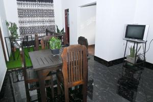 Cette chambre dispose d'une table, de chaises et d'une télévision. dans l'établissement Vindiw Holiday Resort, à Anurâdhapura