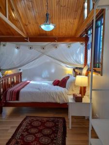 une chambre avec un lit à baldaquin dans une pièce dans l'établissement Quirky Cottage in Centre of Maleny, Walk Everywhere, à Maleny