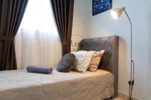 雪邦Elana by Alanis Free Wifi and Netflix的一间卧室配有带枕头和台灯的床