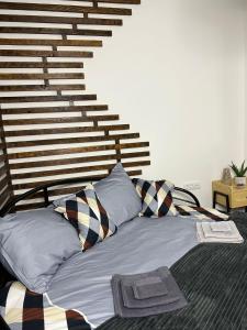 a bedroom with a bed with pillows and a staircase at In Dream Apartman in Inđija