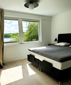 a bedroom with a large bed and a large window at The Luxurious Lakeview Villa near Stockholm in Stockholm
