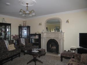 a living room with a fireplace and a mirror at Kinvara Inn B&B in Kinvara
