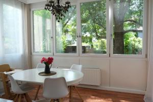 uma sala de jantar com uma mesa branca, cadeiras e janelas em CasaLuxe: Familienfreundliche 115m² in der Stadtmitte em Günzburg