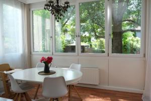 a dining room with a white table and chairs and windows at CASA LUXE - 115qm - Stadtmitte - Familienfreundlich - Parkplatz - 5km zum Legoland in Günzburg