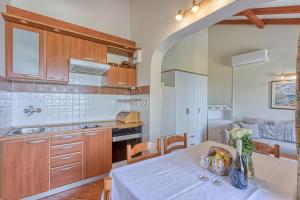 eine Küche mit einem Tisch mit einer Vase Obst darauf in der Unterkunft Valdarke Sea View Apartment - Happy Rentals in Mali Lošinj