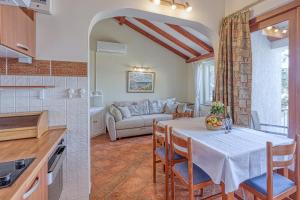 eine Küche und ein Esszimmer mit einem Tisch und einer Couch in der Unterkunft Valdarke Sea View Apartment - Happy Rentals in Mali Lošinj