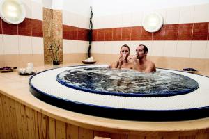 Jirkov的住宿－澤覓克舍維尼哈拉迪克酒店，两人在浴室的浴缸里