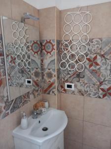 ein Bad mit einem Waschbecken und einem Spiegel in der Unterkunft Regina Lucia casa vacanze in Syrakus
