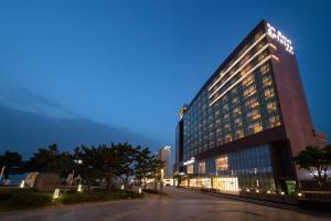 Un grand bâtiment avec des lumières allumées la nuit dans l'établissement Hotel solaire, à Boryeong