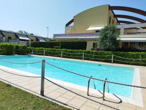 una grande piscina di fronte a un edificio di Appartamento L'Azalea - a due passi da Numana con grande terrazzo e piscina condominiale stagionale a Sirolo