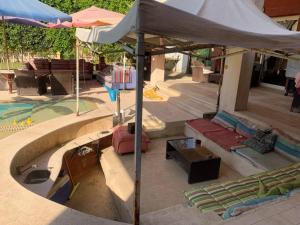 eine Terrasse mit einem Sonnenschirm neben einem Pool in der Unterkunft Perfect family vacation house in King Mariout