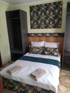 a bedroom with a bed with two towels on it at Willa Warta in Krynica Morska