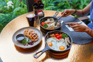 Hotel Indigo Phuket Patong, an IHG Hotel في شاطيء باتونغ: طاولة عليها طبقين من طعام الإفطار
