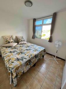 een slaapkamer met een bed en een raam bij Cocooning Orava a Papeete in Papeete
