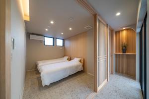 a bedroom with two beds and a window at Besso姫路 in Himeji +28 photos