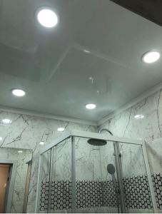 a bathroom with a shower and a ceiling with lights at Супер-квартира в самой эко-зеленой части Алматы in Almaty
