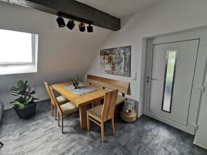 ein Esszimmer mit einem Holztisch und Stühlen in der Unterkunft Skyline klimatisierte Dachgeschoss-Wohnung in Dornbirn mit Blick ins Rheintal in Dornbirn