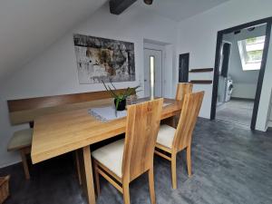 a dining room with a wooden table and chairs at Skyline klimatisierte Dachgeschoss-Wohnung in Dornbirn mit Blick ins Rheintal in Dornbirn