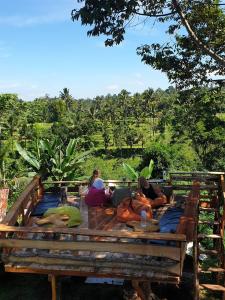 a group of people sitting on a wooden table at Tetebatu Sama Sama Bungalows in Tetebatu