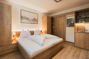 a bedroom with a large bed with white sheets at Apartments Morandell in Fulpmes