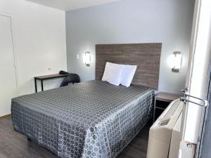 um quarto de hotel com uma cama e uma cadeira em Masters Inn Atlanta - Doraville at I-85 & 285 em Atlanta