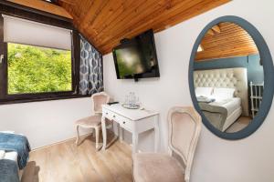 a room with a mirror and a bed and a table at Pannonhalma Panzió in Pannonhalma