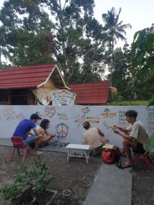 a group of people sitting around a wall at Tetebatu Sama Sama Bungalows in Tetebatu