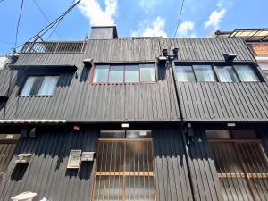 大阪市にある梅田の時尚街区に位置する独栋町屋 中崎町駅まで徒歩3分 最大8名様までの広々とした宿泊スペースの窓のある黒屋根の建物