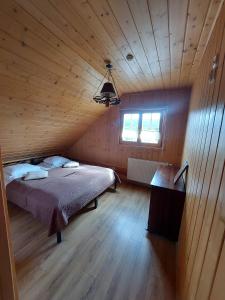 a bedroom with a bed in a wooden cabin at Bieszczadzkie Marzenie in Wetlina