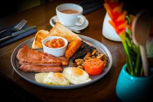 a plate of breakfast food on a table with a cup of coffee at OYO The Townhouse in Durham