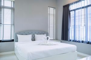 una camera da letto con un letto bianco con un fiocco bianco di so happy pool villa hua hin a Ban Bo Fai (1)