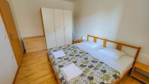 ein kleines Schlafzimmer mit einem Bett mit Blumenbettdecke in der Unterkunft Apartments Dani in Izola