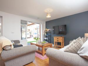 a living room with two couches and a table at Trebisken in Porthtowan