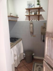 a small kitchen with a stove and a trash can at Emily house in Pozzallo